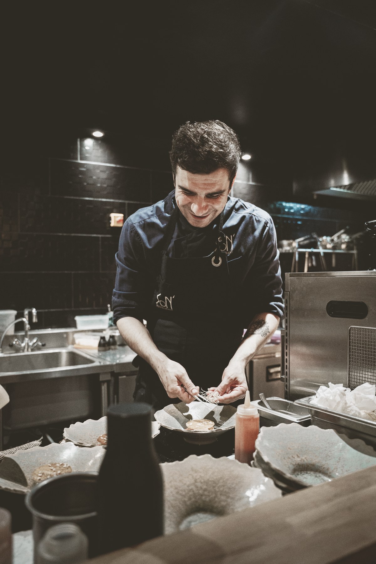 Sylvain Renzetti dressant une assiette en cuisine