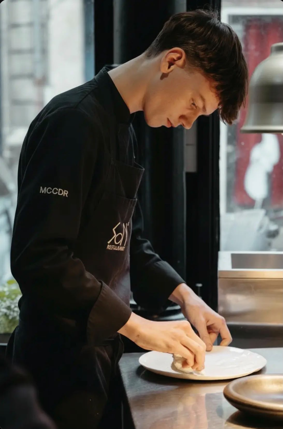 Eden Gros dressant une assiette en cuisine